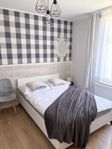 a bedroom with a bed and a checkered wall at Willa Azur blisko plaży, centrum Mielna in Mielno