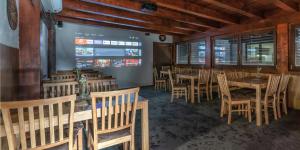 a dining room with wooden tables and chairs at Penzion Horalka in Hlinsko