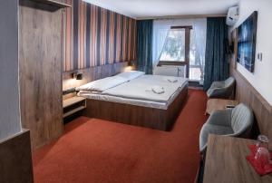 a small room with a bed and a table and chairs at Penzion Horalka in Hlinsko