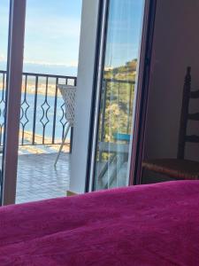 a bedroom with a view of the ocean from a balcony at Puig Rom Pau Vila in Roses