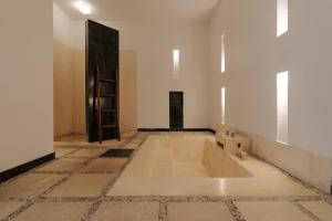 a bathroom with a tub in the middle of a room at The Seminyak Suites Private Villas in Seminyak