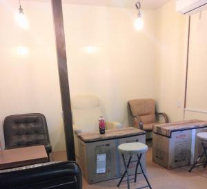 a waiting room with chairs and tables and boxes at OKAYAMA Backpackers in Okayama