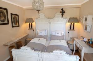a bedroom with a white bed with two pillows at Boutique Hotel Haus Noge in Westerland