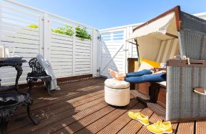 a woman is sitting on a balcony at Boutique Hotel Haus Noge in Westerland