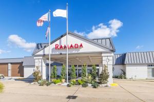 a building with a raminia sign and two flags at Ramada by Wyndham Houma in Houma