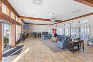 a living room with blue couches and a bar at Ramada by Wyndham Houma in Houma