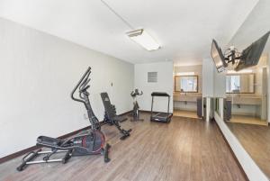 a gym with treadmills and exercise bikes in a room at Ramada by Wyndham Houma in Houma