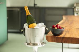 a bottle of champagne and a bucket of strawberries at Boutique Hotel Haus Noge in Westerland