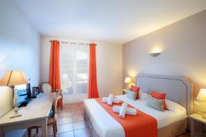 a hotel room with two beds and a desk and a computer at Hôtel La Bastide Saint Martin in Carcassonne