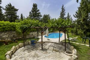 a swimming pool in a backyard with a pergola at Manoli's House in Douliana