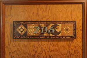 a sign on a wooden door with the number at Hakuba Pension & Log Hotel Meteor in Hakuba
