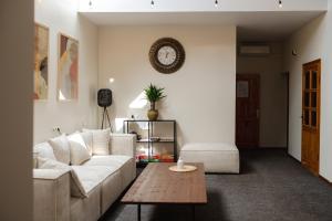 a living room with a white couch and a table at Hang The Hat House in Valmiera