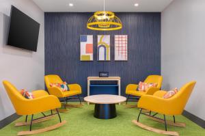 a waiting room with chairs and a table and a tv at Spark by Hilton Douglasville Atlanta West in Douglasville