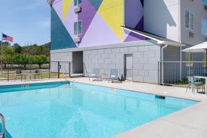 a swimming pool in front of a building at Spark by Hilton Douglasville Atlanta West in Douglasville