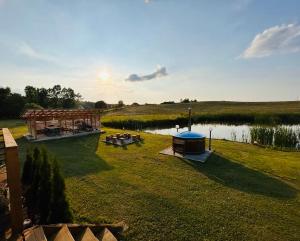 a view of a pond with a gazebo at Dom BAnia Mazury SPA in Kukowo