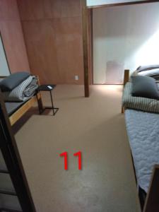 a room with two beds and a room with the number at OKAYAMA Backpackers in Okayama