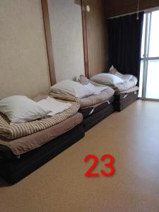 two beds in a room with a timestamp in the foreground at OKAYAMA Backpackers in Okayama