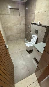 a bathroom with a toilet and a sink at Kaveri Pool Pavilion in Paravūr