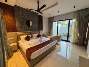 a bedroom with a large bed with a ceiling fan at Kaveri Pool Pavilion in Paravūr