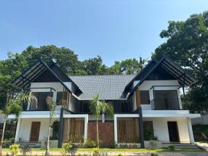 a house with a black roof at Kaveri Pool Pavilion in Paravūr
