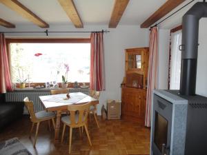 ein Wohnzimmer mit einem Tisch und einem Herd in der Unterkunft Landhaus Bindermoos in Schönau am Königssee