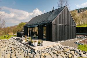 a black house with a black roof at Folga in Tarnawa Dolna