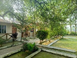 a house with trees in front of a yard at Narayani View Resort in Bharatpur