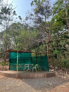 a tent with a table and a chair on a platform at Infinity Farm Grove in Olavakod Junction +3 photos