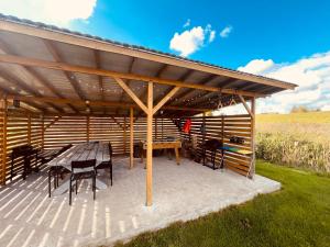 a wooden pavilion with a table and chairs under it at Dom BAnia Mazury SPA in Kukowo