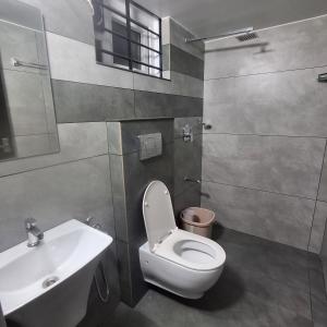a bathroom with a toilet and a sink at Nana's Residency, Cochin in Alwaye
