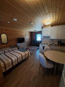 a bedroom with a bed and a table and a kitchen at Venetsianranta in Saarijärvi