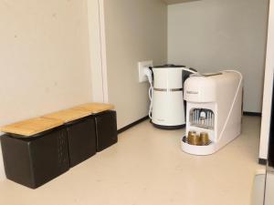 a room with a coffee maker and a bench at דיויד רזידנט & ספא - by Desert 360 Mountain & sea view in Eilat