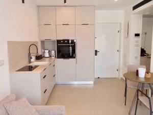 a kitchen with white cabinets and a table at דיויד רזידנט & ספא - by Desert 360 Mountain & sea view in Eilat