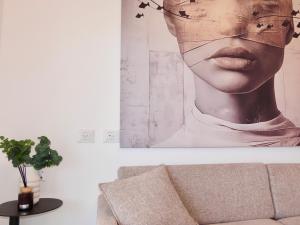 a painting of a woman with glasses on a wall at דיויד רזידנט & ספא - by Desert 360 Mountain & sea view in Eilat +65 photos