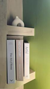 three books on a shelf in a room at Olive Groove Chios in Chios