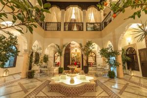 un grand hall avec une fontaine au milieu d'un bâtiment dans l'établissement Riad Nasreen, à Marrakech