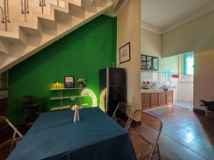 a dining room with a blue table and a green wall at XOM House - Nhà nguyên căn trung tâm Pleiku in Plei Brel (2) +6 photos