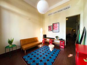 a living room with a couch and a blue rug at XOM House - Nhà nguyên căn trung tâm Pleiku in Plei Brel (2)