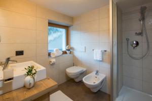 a bathroom with a toilet and a sink and a shower at Ciasa Col Cuch in La Villa