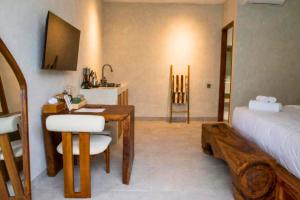 a bedroom with a desk and a bed and a room with a bed at Bilha 1 BR Deluxe Suite Room in Kuta Lombok +3 photos
