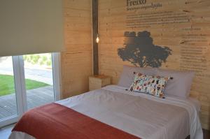 a bed in a room with a wooden wall at Óbidos Wood Villas in Olho Marinho +36 photos