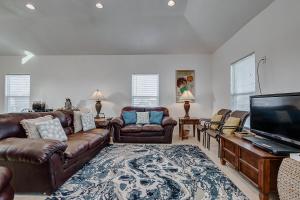 a living room with leather furniture and a flat screen tv at Molly's Place home in Crystal Beach