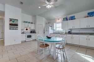 a kitchen with white cabinets and a blue table and chairs at Molly's Place home in Crystal Beach