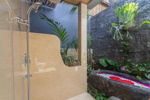 a bathroom with a shower and a bathtub with plants at Bara Villa by GenuineHost in Tegalalang +16 photos
