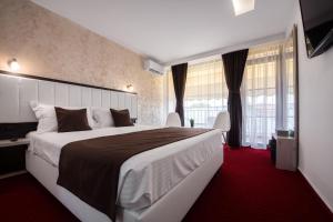 a hotel room with a large bed and a red carpet at Km ZerO - Vama Veche in Vama Veche +53 photos