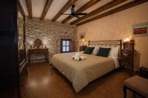 a bedroom with a large bed with a ceiling fan at Cal París Rural in La Donzell D'Urgell +45 photos