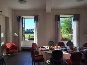 a dining room with a table and chairs and windows at Domaine de Chantemerle in Moncoutant