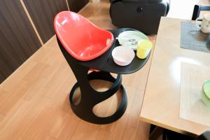 a red chair sitting next to a table at 民泊 丘の上 in Seto