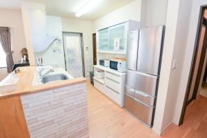 a large kitchen with a stainless steel refrigerator at 民泊 丘の上 in Seto +13 photos