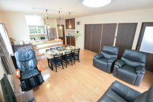 a living room with a couch and a table and chairs at 民泊 丘の上 in Seto